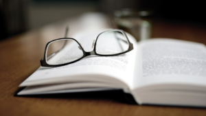 Glasses on top of an open textbook, suggesting someone was analyzing text of some type.