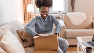 Someone on their couch is delighted to open a personalized package from their favorite retailer