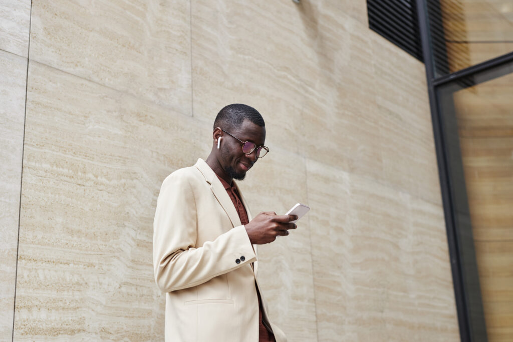 Side view of a young, confident exec while he looks at his phone