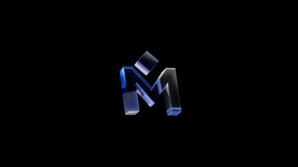 A metallic, three-dimensional letter M with a small tilted square above it, set against a black background. The letter has a sleek, glossy blue and silver gradient effect.